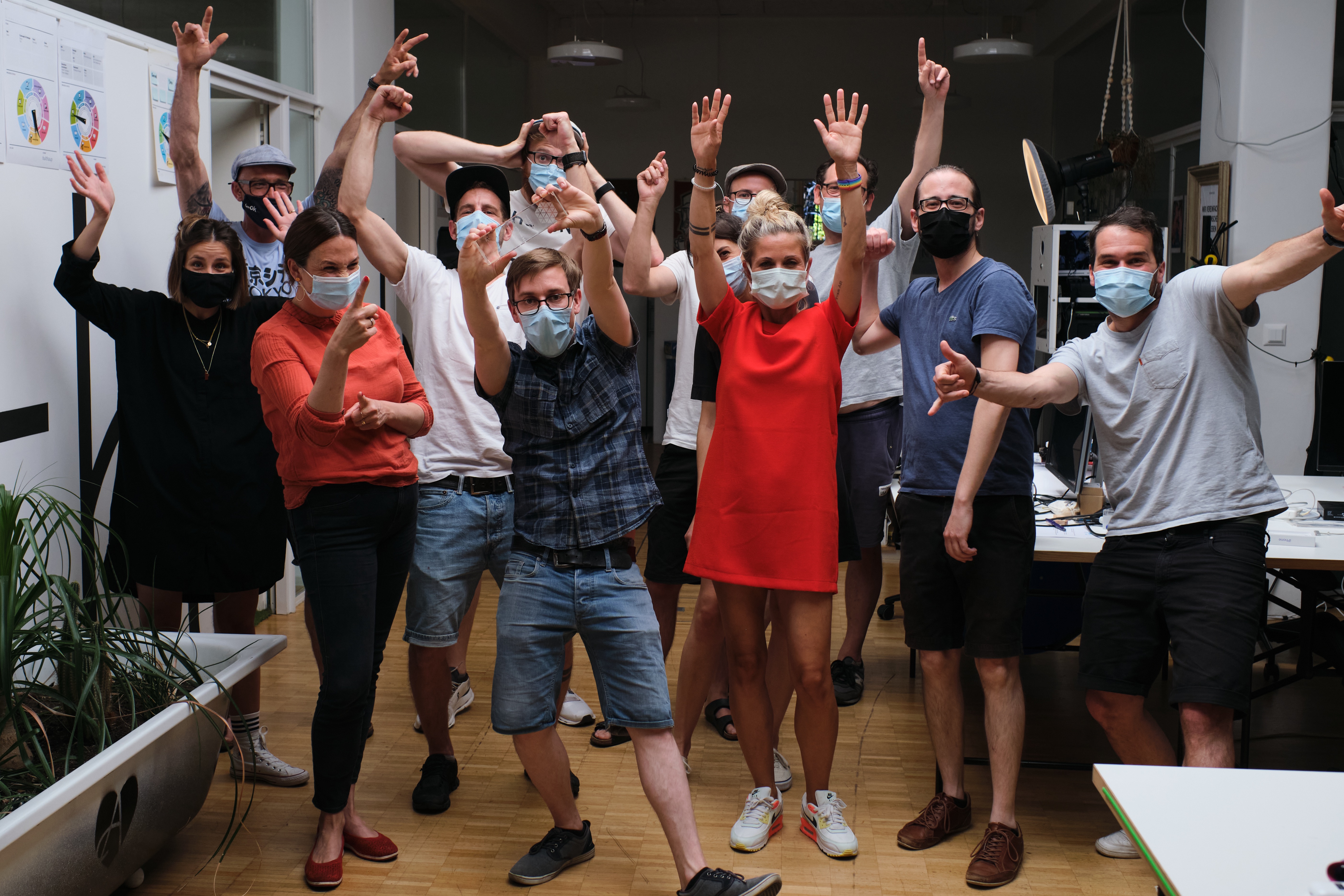 Gruppenfoto von Apps with love Mitarbeitenden mit dem Smart IoT Award, alle tragen eine Maske und strecken fröhlich die Hände in die Luft