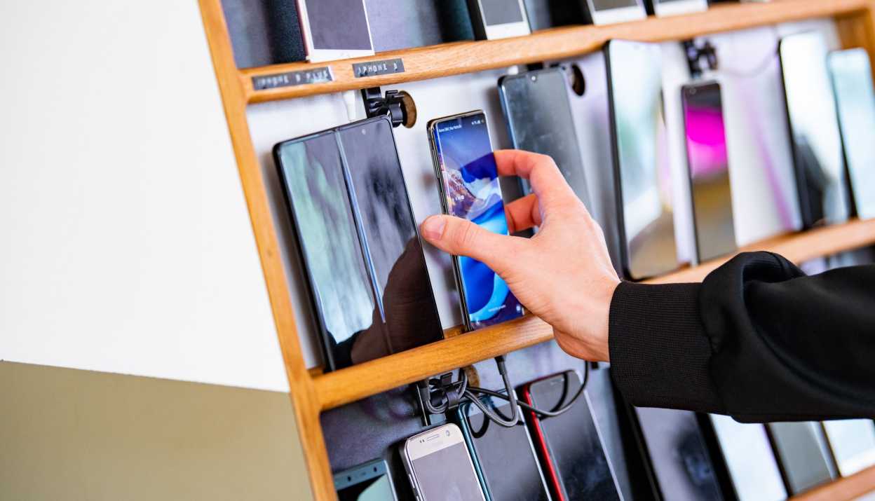 Hand, die nach Smartphone greift