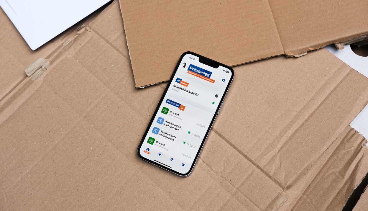 Dräggwägg App geöffnet auf einem iPhone, das auf Karton liegt.