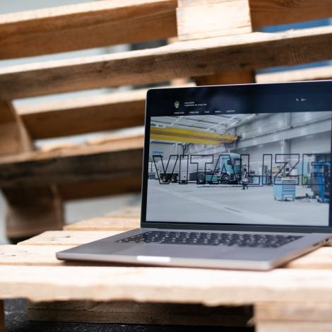 LOG-VISION Website geöffnet auf einem MacBook das auf Euro Palette steht