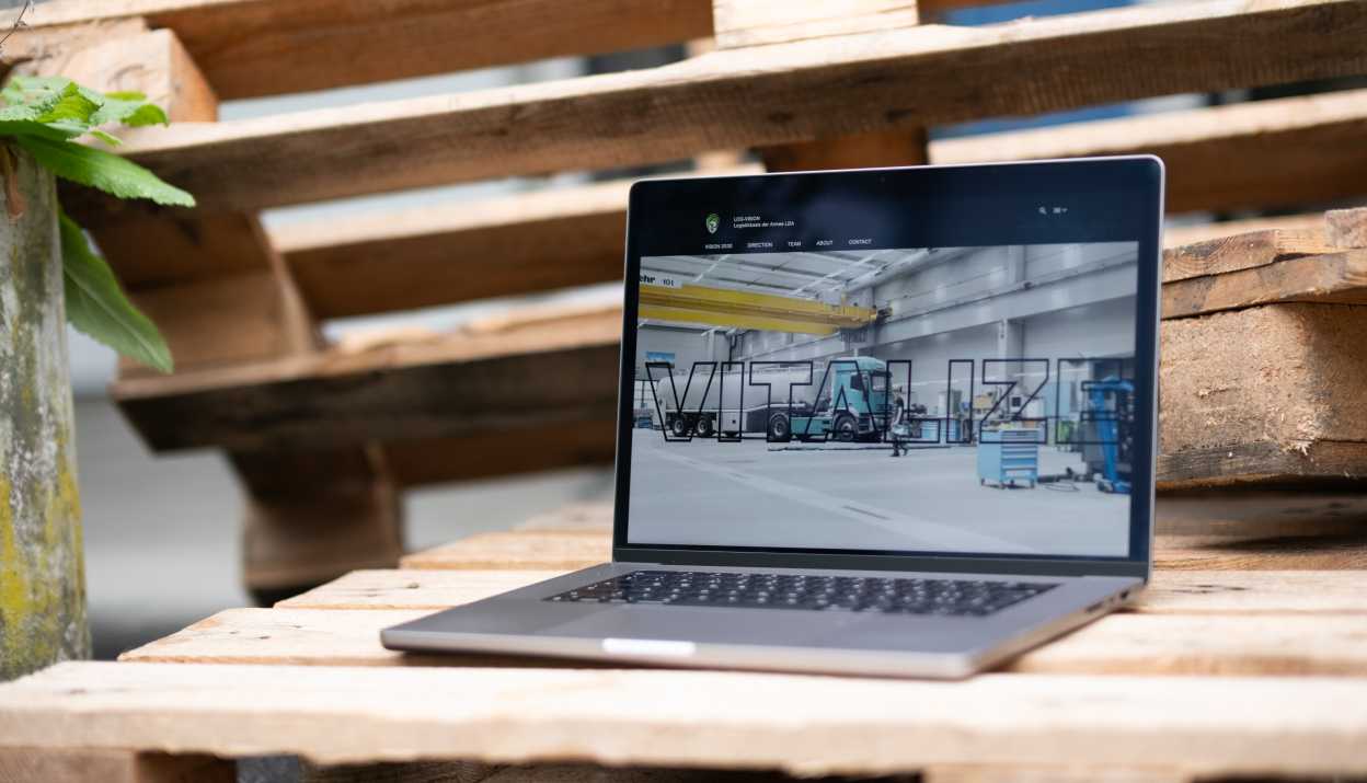 LOG-VISION website opened on a MacBook standing on a Euro pallet