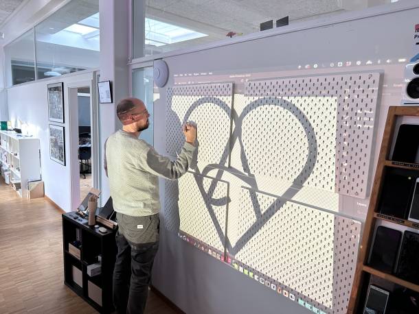 Stefan Spieler draws the Apps with love logo on the new device wall