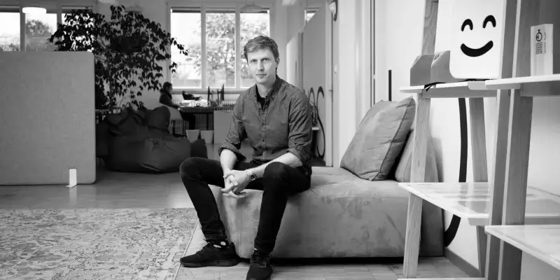 Till Könneker sitz auf einem Sofa im Büro von Apps with love in Bern